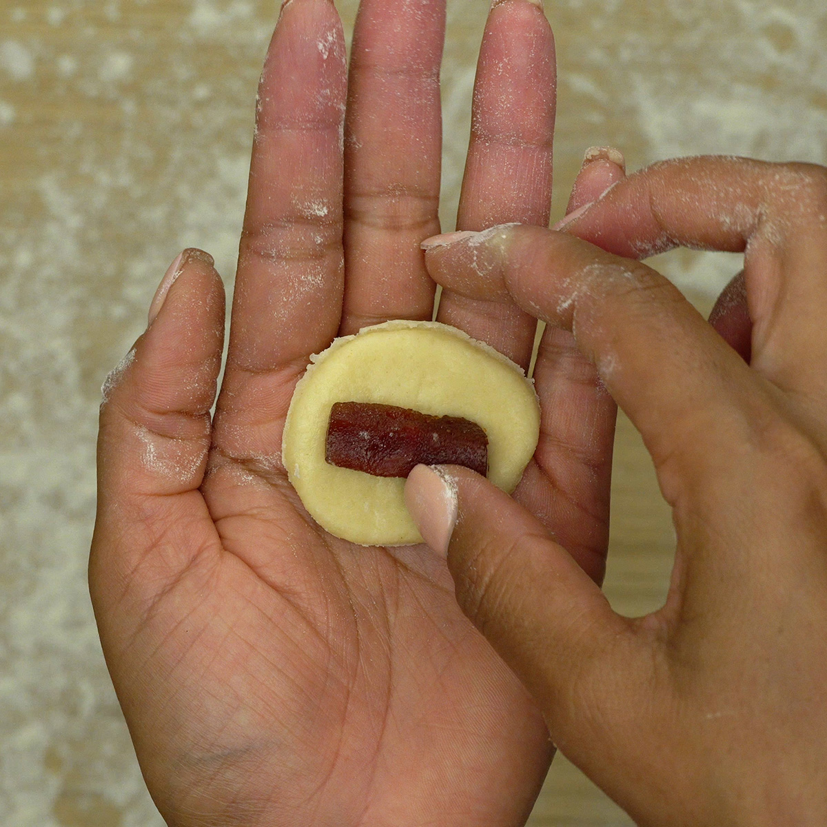 Biscoito recheado com goiabada sendo montado antes do forno.