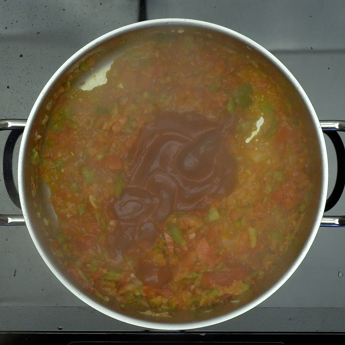 Extrato de tomate sendo incorporado ao molho do cachorro-quente.