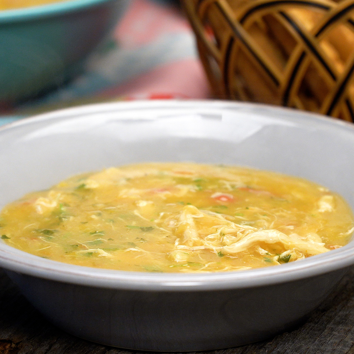 Caldo de frango com mandioca servido quente com coentro fresco por cima.