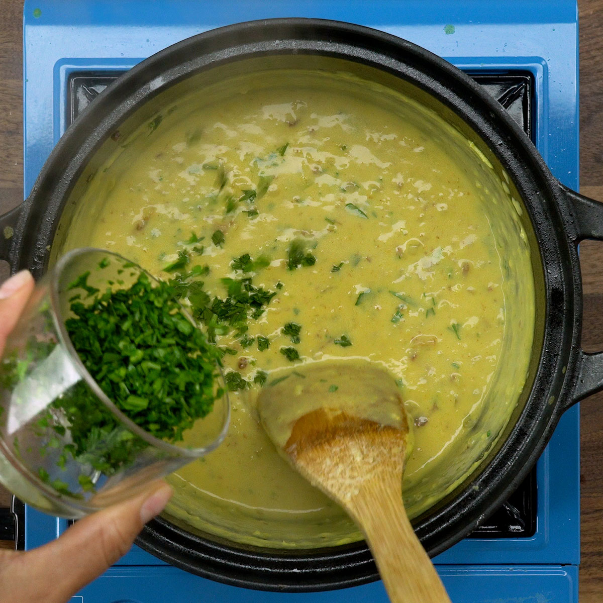 Adicionando salsa fresca picada ao creme de milho com bacon.