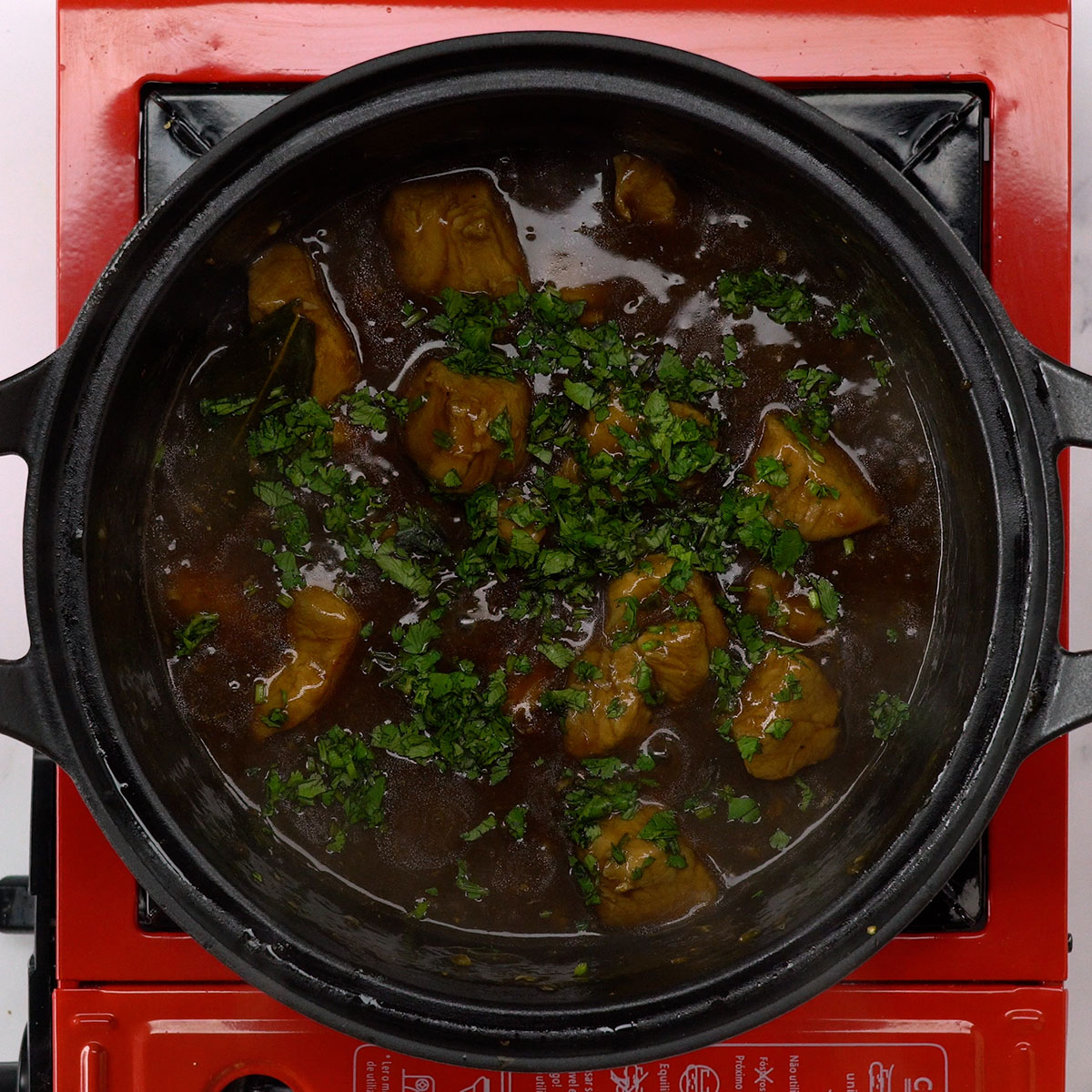 Carne suína pronta com salsa picada por cima.