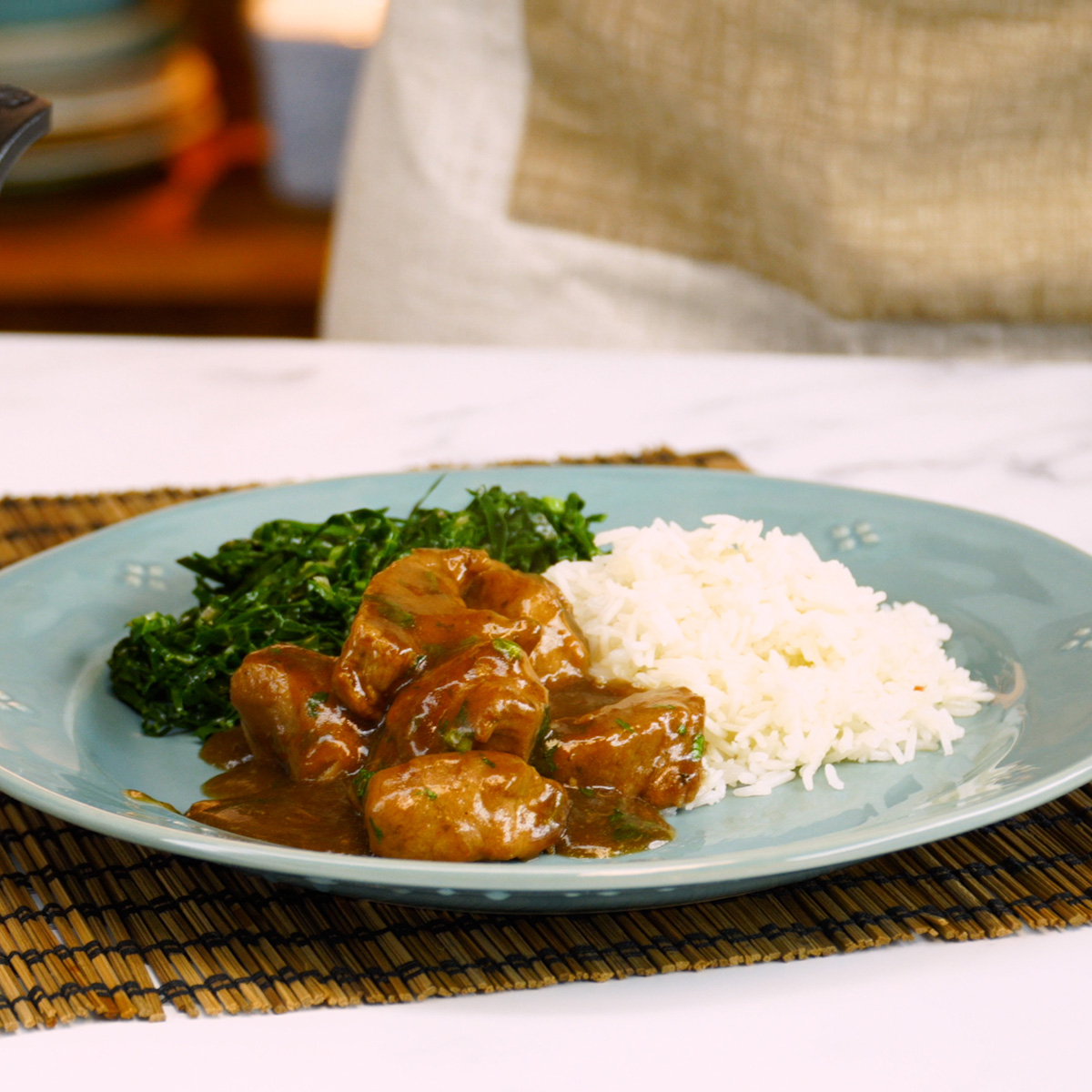 Dadinho suíno na cerveja preta servido com acompanhamento no prato.
