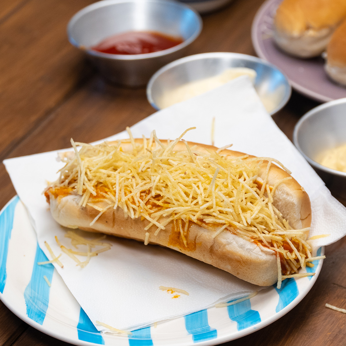 Cachorro-quente cremoso pronto servido no prato.