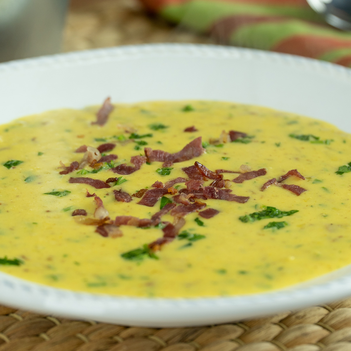 Creme de milho com bacon sendo servido no prato.