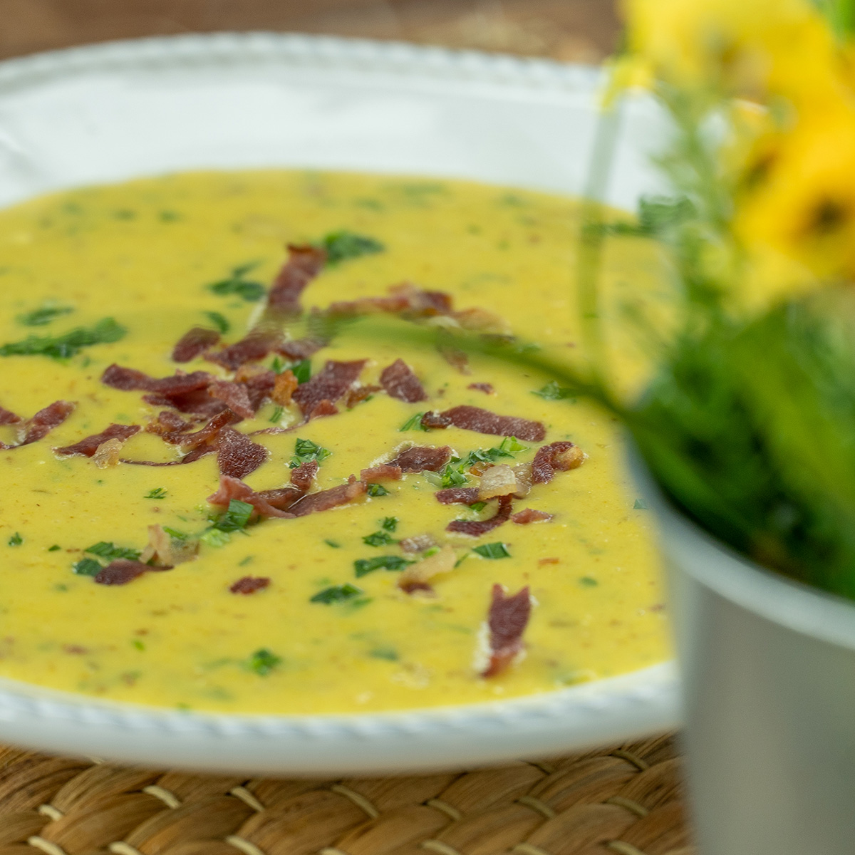 Creme de milho com bacon sendo servido no prato.