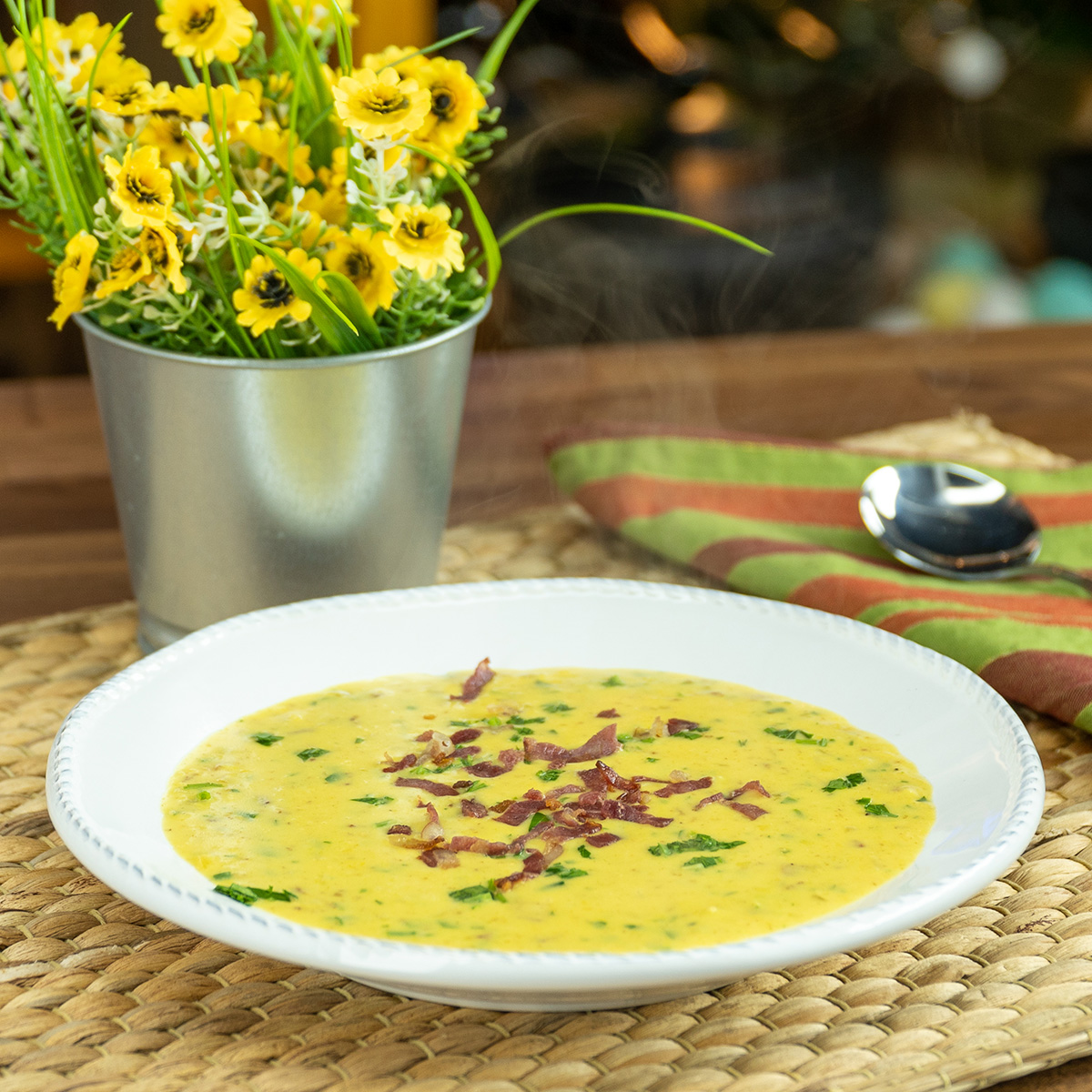 Creme de milho doce com bacon sendo servido no prato.