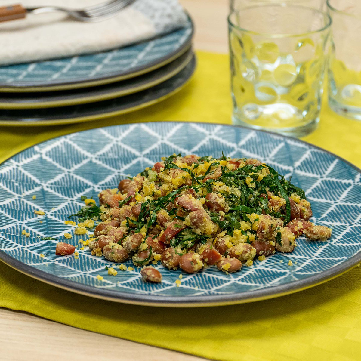 Empratamento farofa de feijão tropeiro sendo servido.