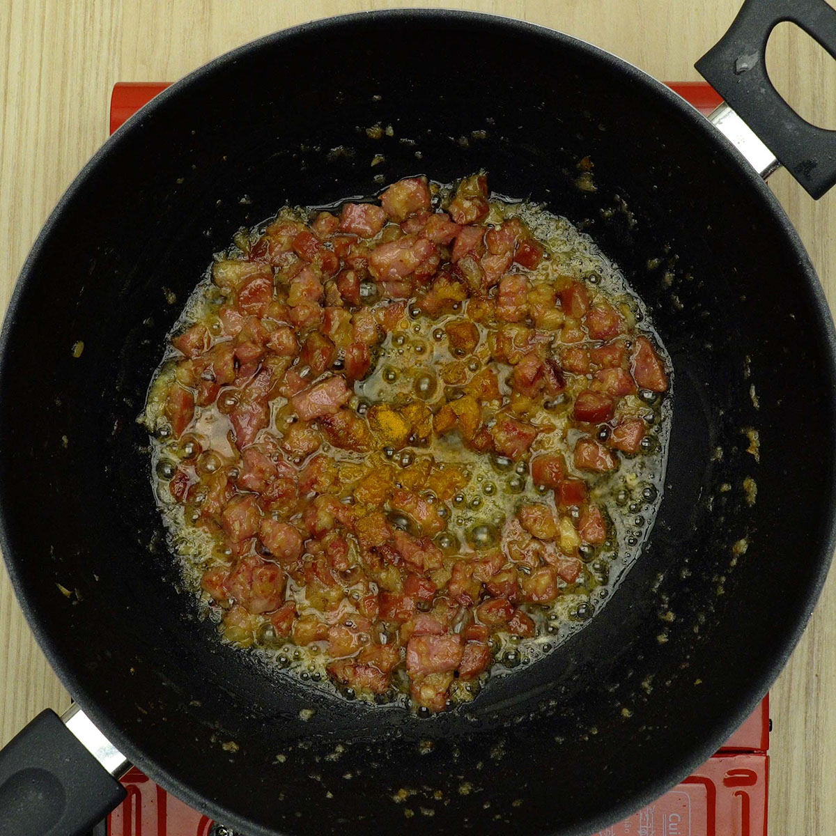 Alho e açafrão sendo adicionados ao refogado com manteiga derretendo.