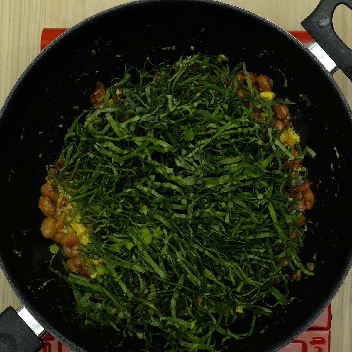 Couve sendo misturada à farofa ainda verde e levemente murcha.