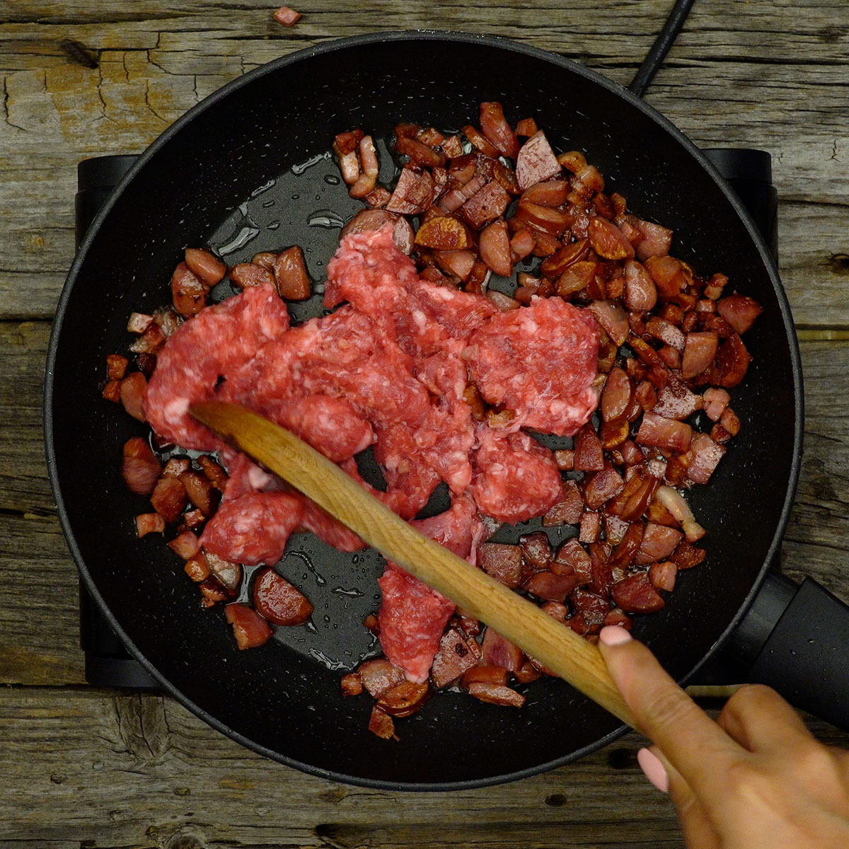 Linguiça de churrasco dourando junto com bacon e calabresa.