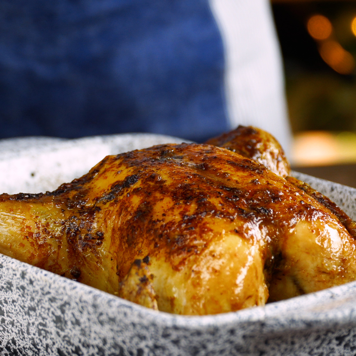 Frango assado pronto, dourado e suculento, servido no refratário.