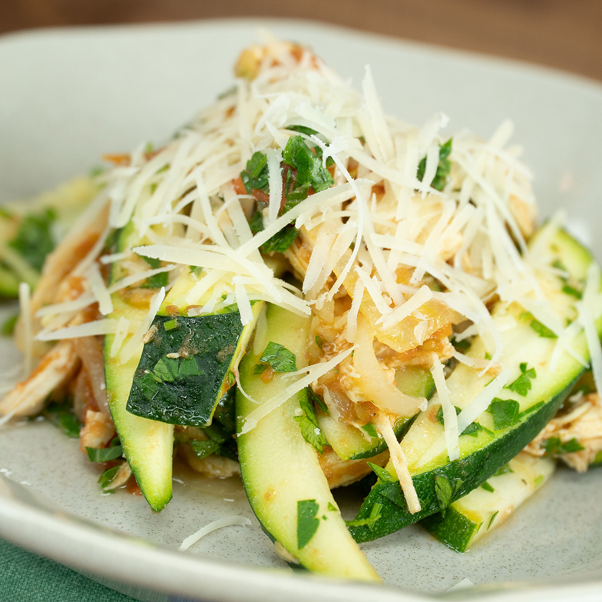 Frango com abobrinha finalizado com queijo parmesão ralado.