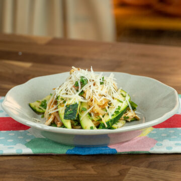 Empratamento frango com abobrinha finalizado com queijo parmesão ralado.
