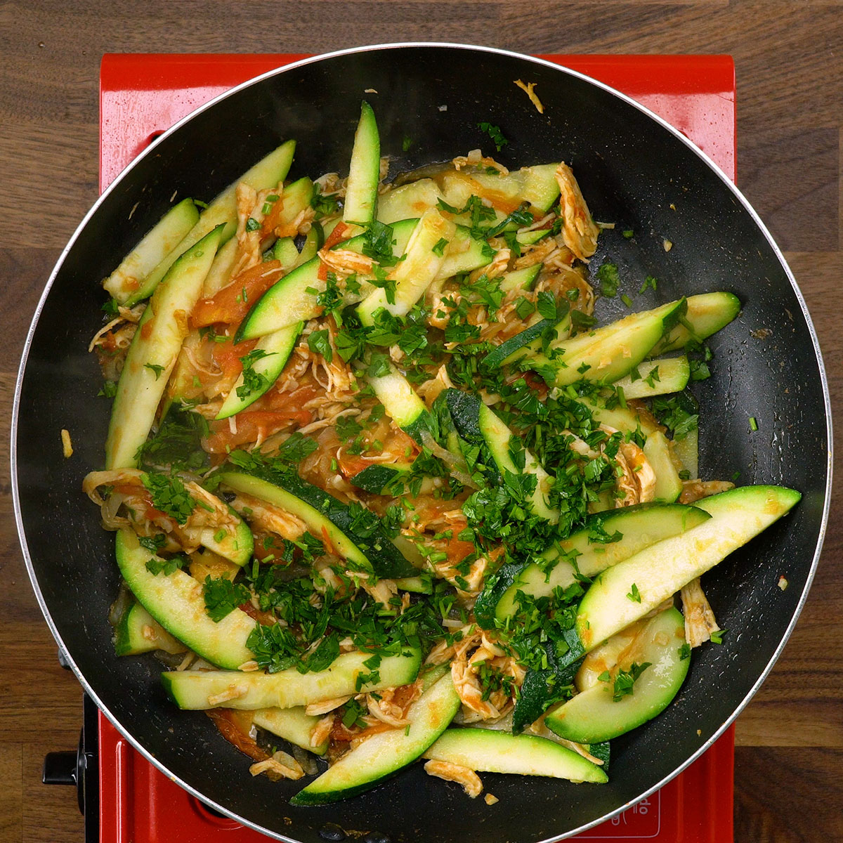 Salsa fresca sendo adicionada ao frango com abobrinha.