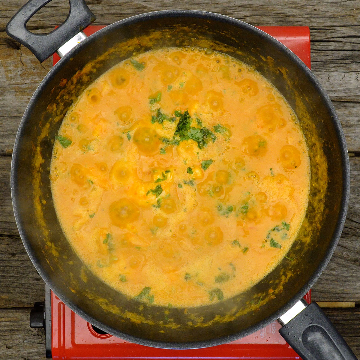 Moqueca de camarão finalizada com coentro fresco picado.