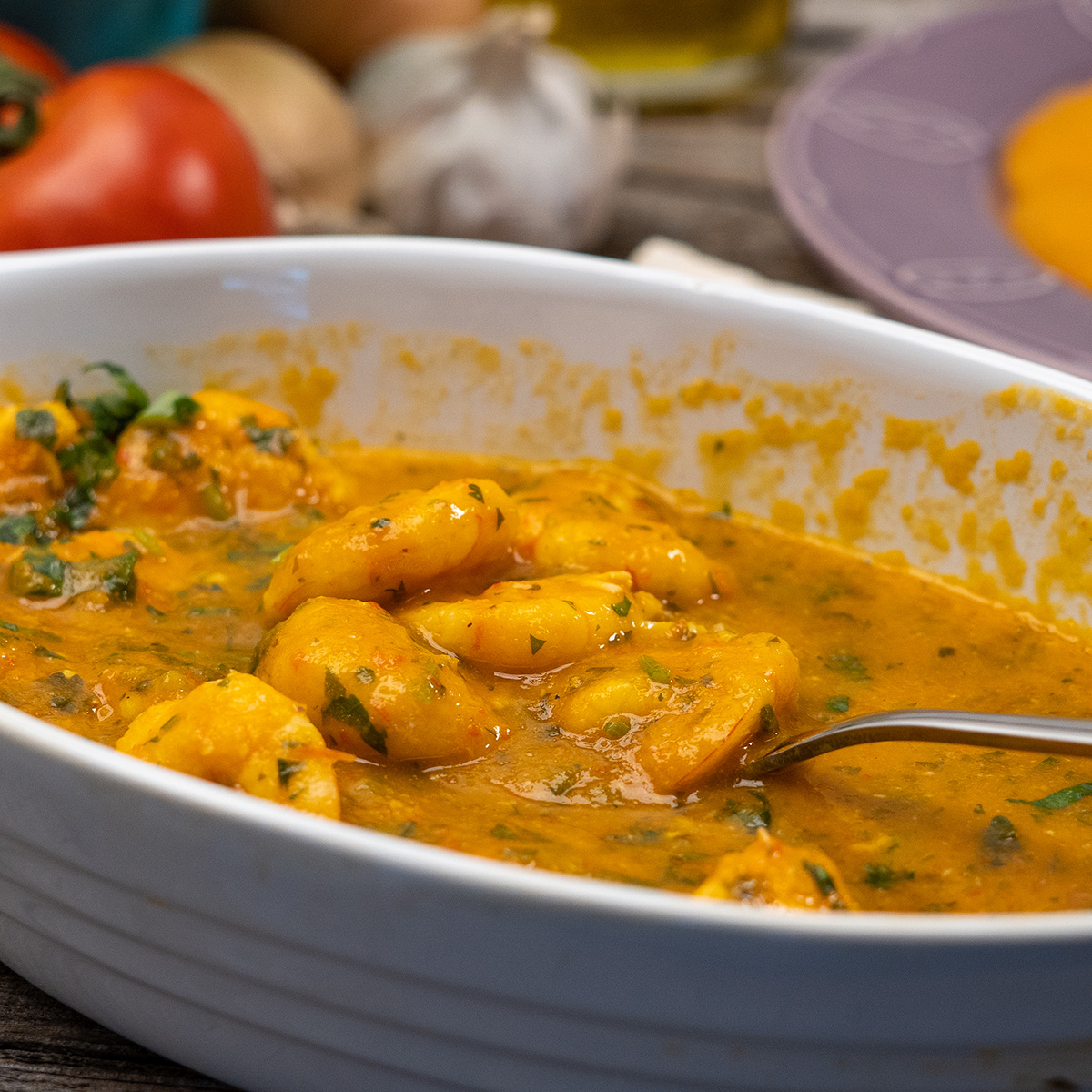 Moqueca de camarão sendo servida em travessa.