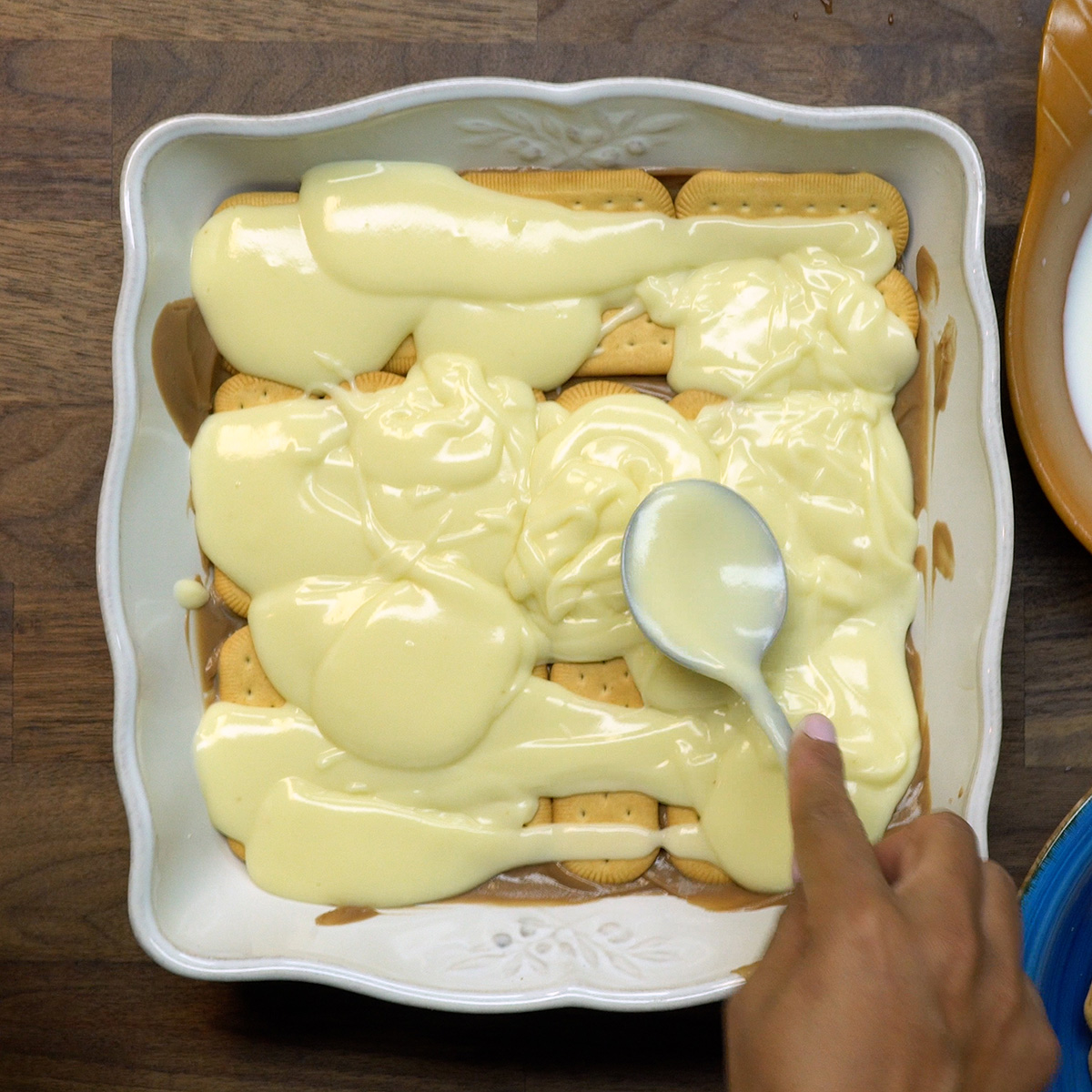 Camadas alternadas de creme branco, creme de chocolate e biscoito formando o pavê.