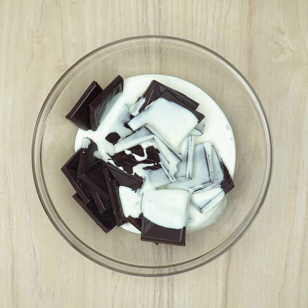 Chocolate meio amargo derretido com creme de leite para a cobertura cremosa.