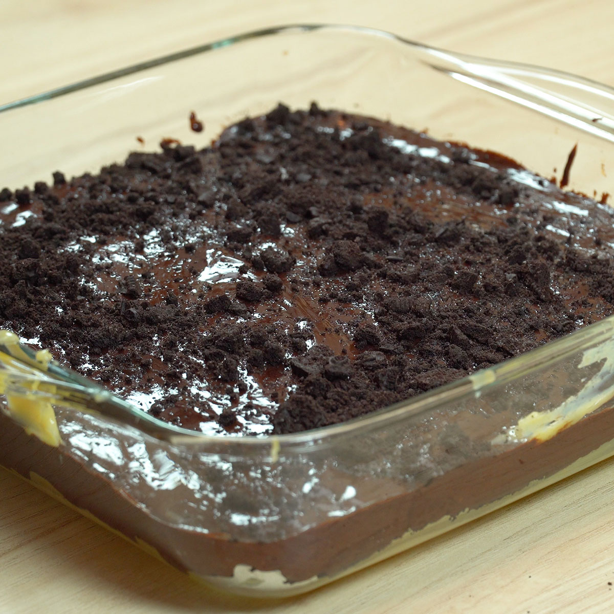 Ganache de chocolate com cobertura cremosa e Oreo triturado por cima.