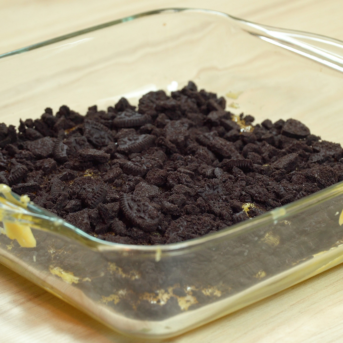 Creme branco colocado na travessa com Oreo triturado.