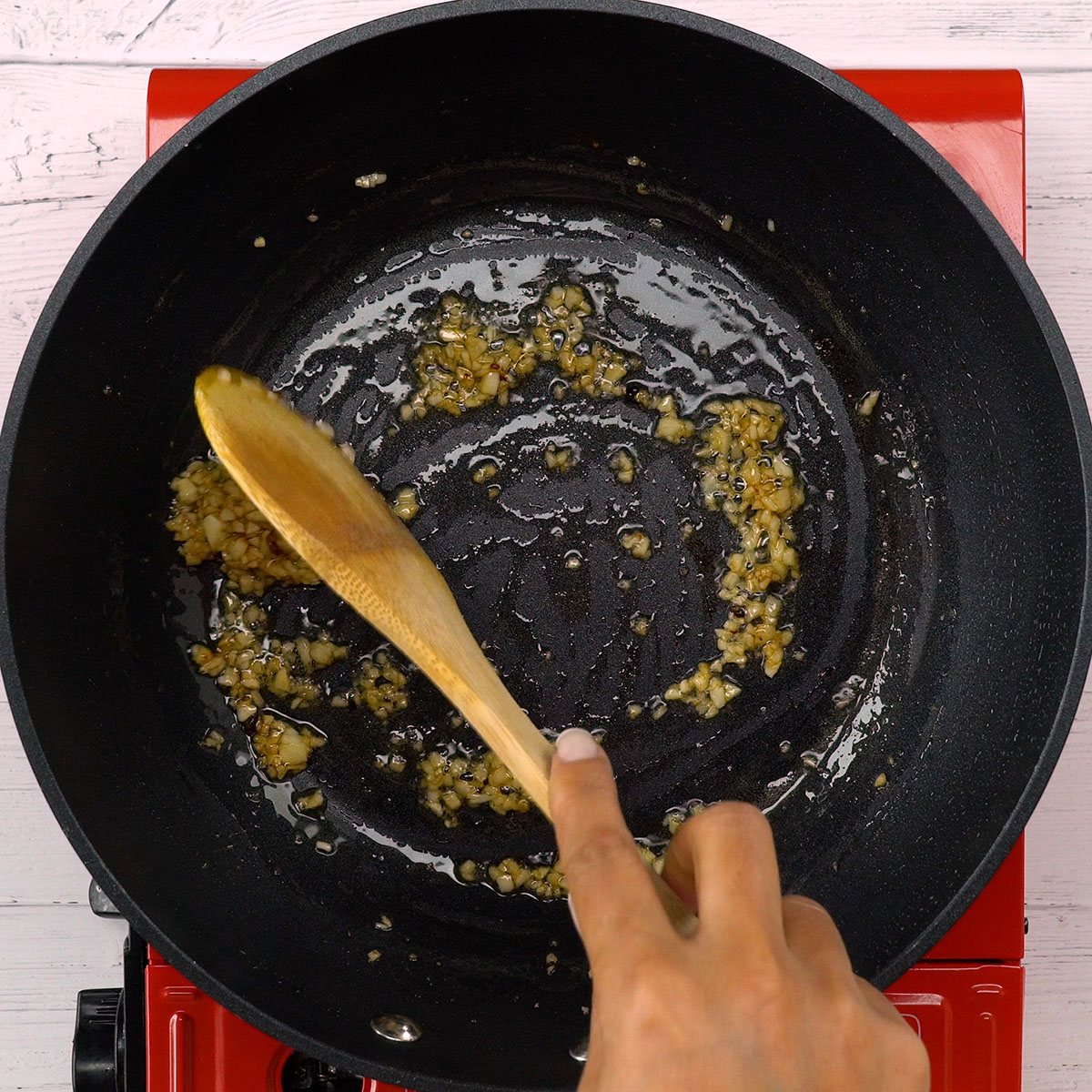 Alho picado sendo refogado na frigideira.