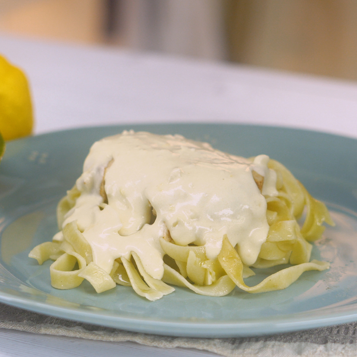 Tagliatelle servido com frango dourado e molho cremoso.