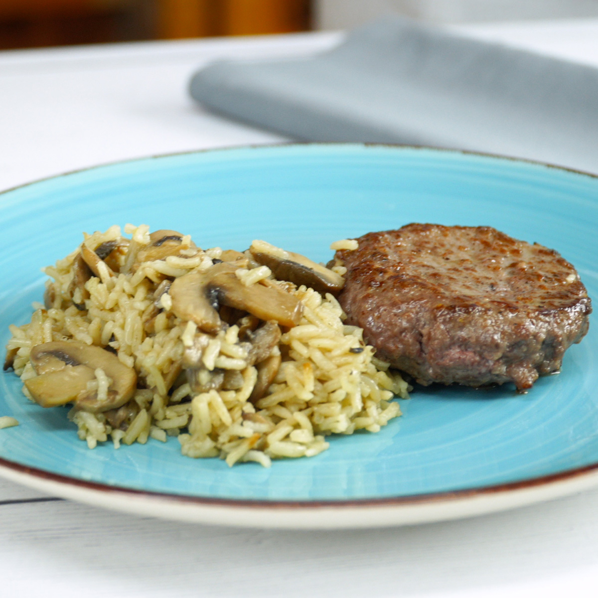 Arroz de cogumelos com hambúrguer servido no prato para o almoço.