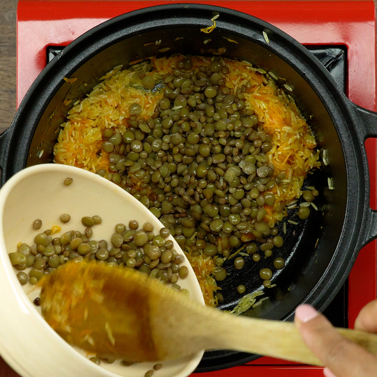 Lentilhas cozidas sendo adicionadas ao arroz durante o preparo da receita.