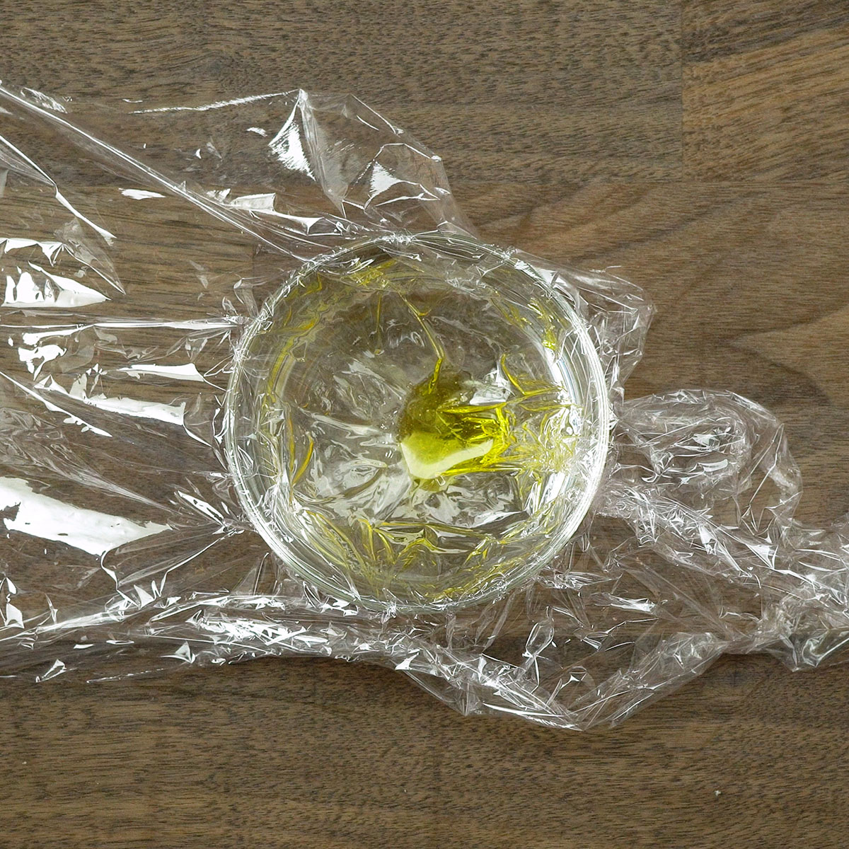 Copo forrado com plástico filme para preparar ovo poché caseiro.