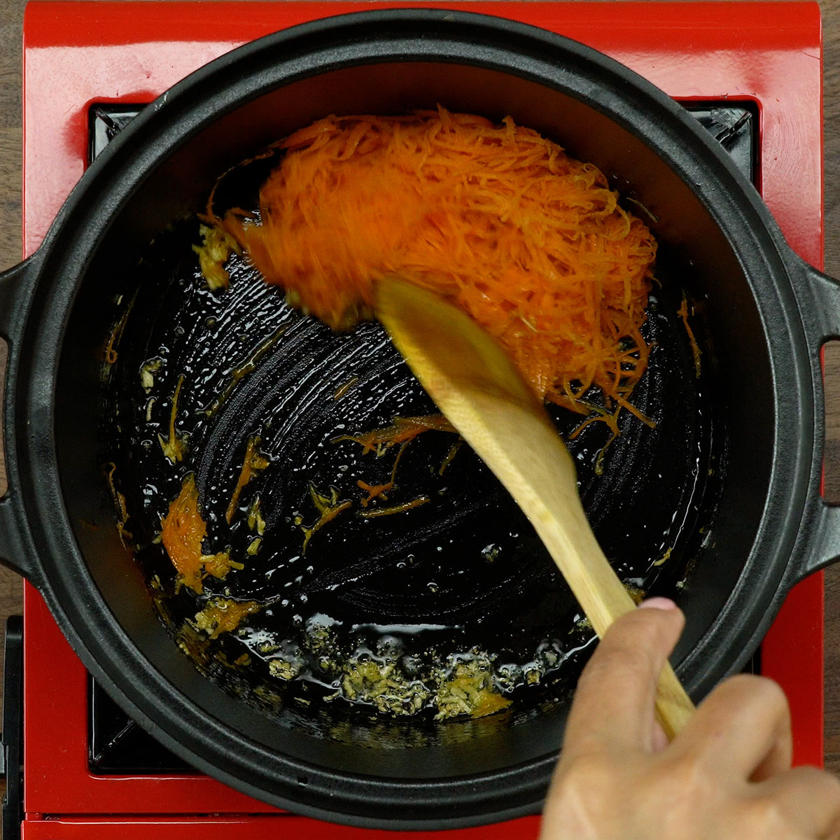 Alho e cenoura refogando no azeite para preparar arroz de lentilhas com ovo poché.