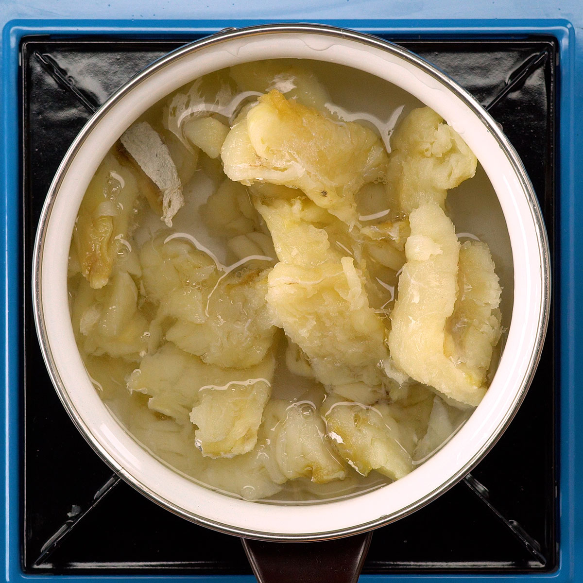 Bacalhau cozido e desfiado para preparar bacalhau gratinado cremoso.