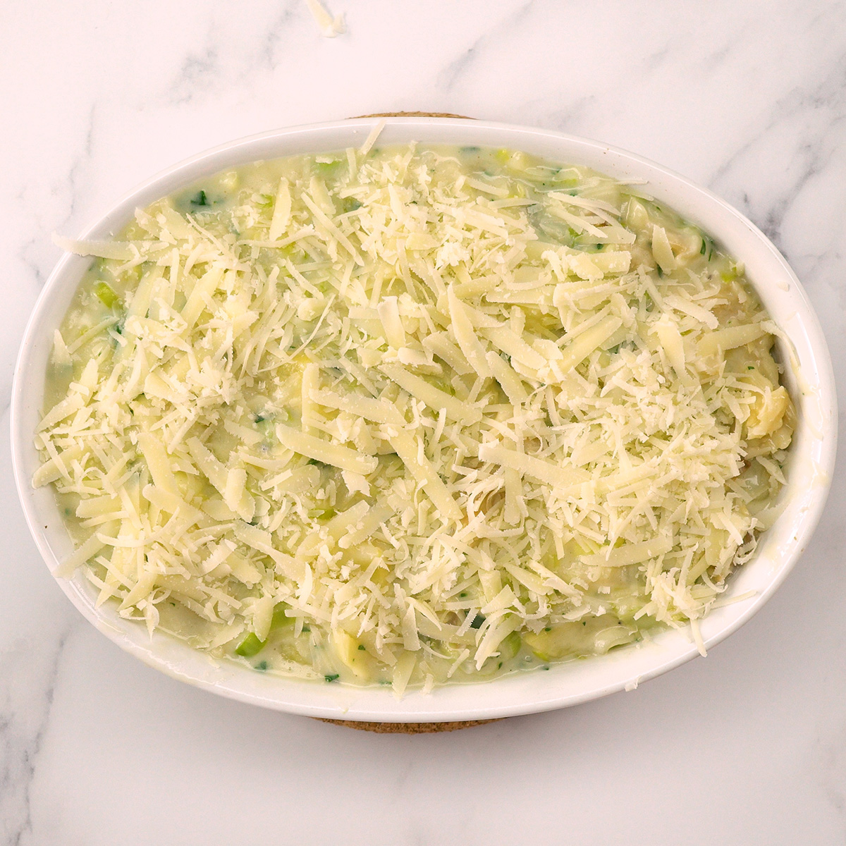 Bacalhau gratinado montado na travessa com queijo parmesão.
