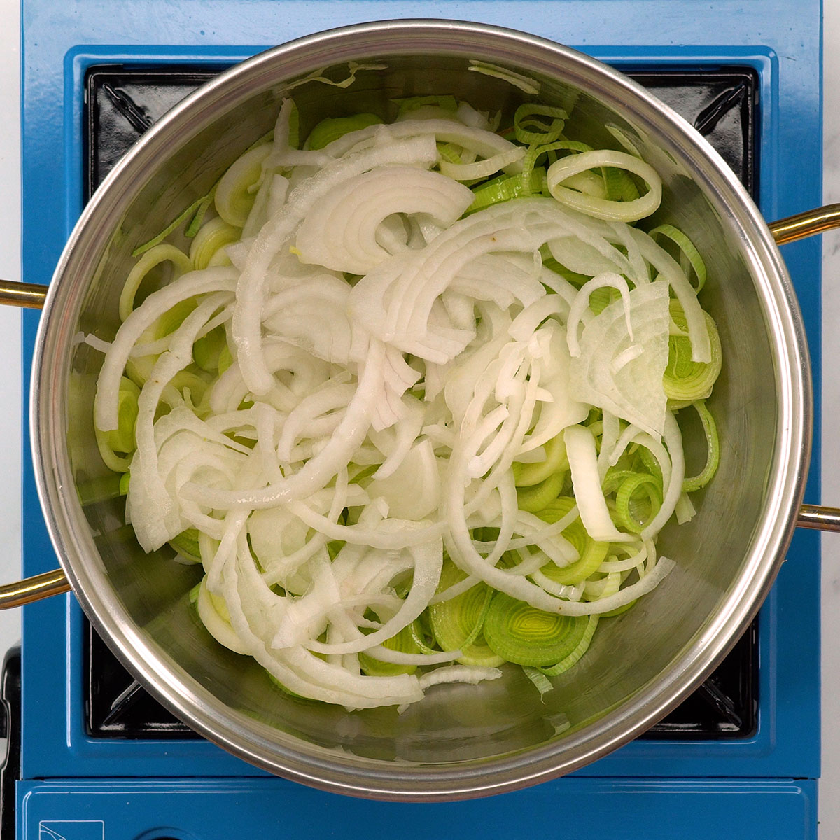 Alho-poró e cebola refogados para recheio de bacalhau gratinado.