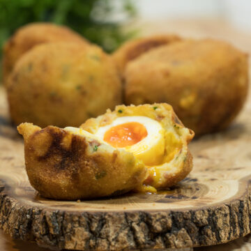 Batata surpresa com ovo e bacon sendo servido e cortado ao meio.
