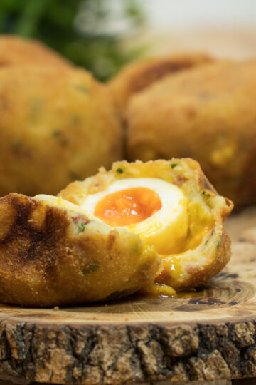 Batata surpresa com ovo e bacon sendo servido e cortado ao meio.