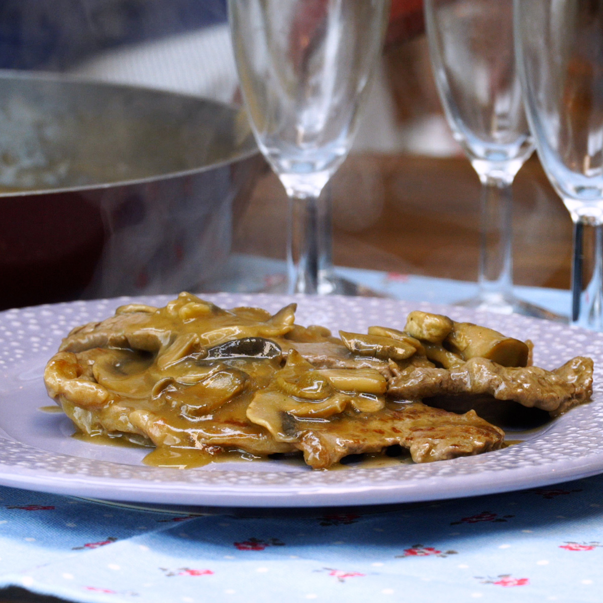 Bifes ao molho madeira finalizados e servidos no prato.