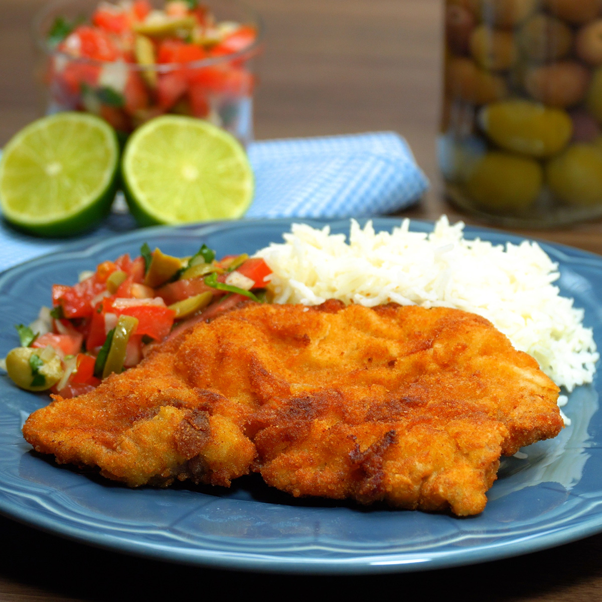 Bifes de porco panados servidos com arroz branco e salada.
