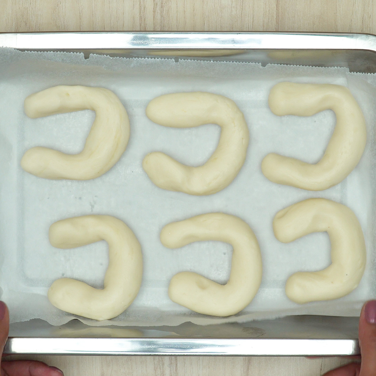 Biscoitos de polvilho assando até dourar levemente nas bordas.