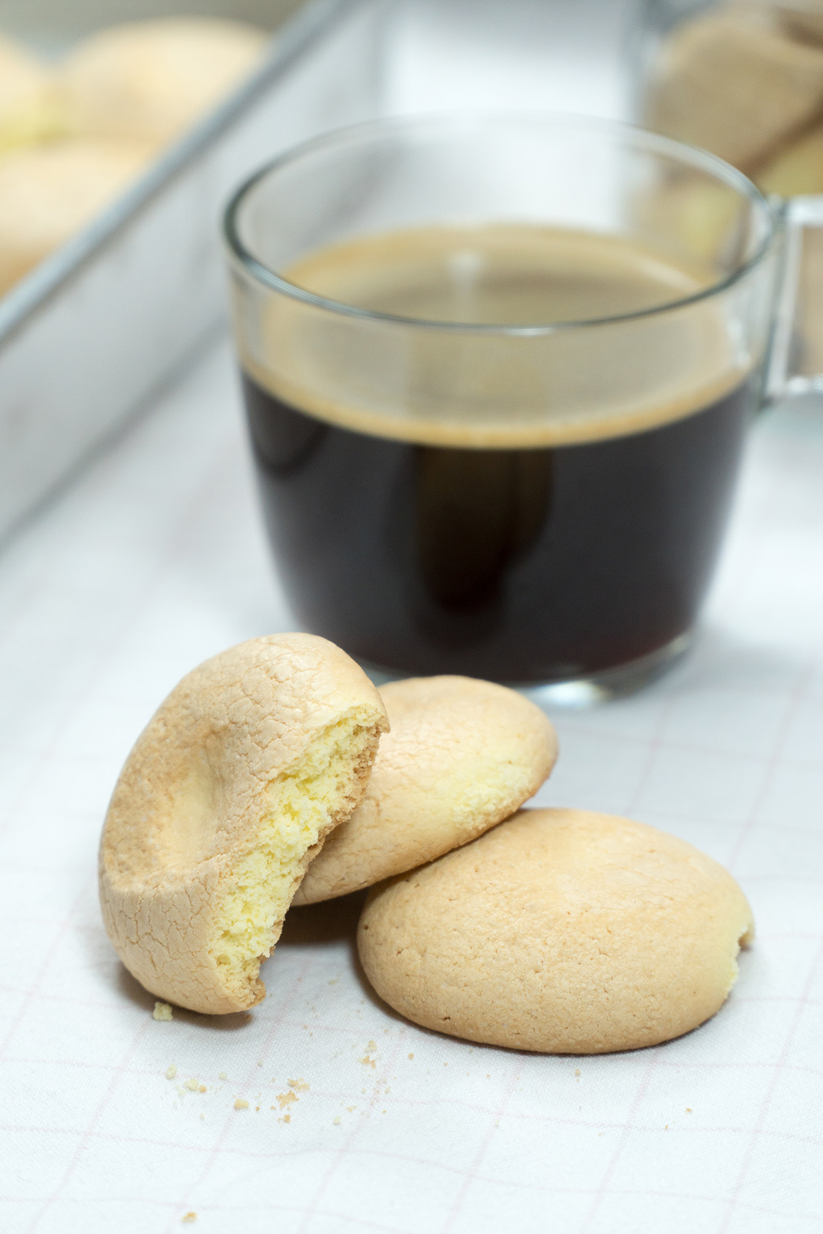Biscoitos de fubá prontos acompanhado de uma xícara de café.