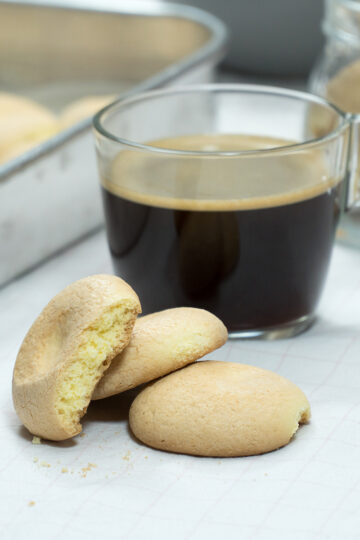 Biscoitos de fubá prontos acompanhado de uma xícara de café.