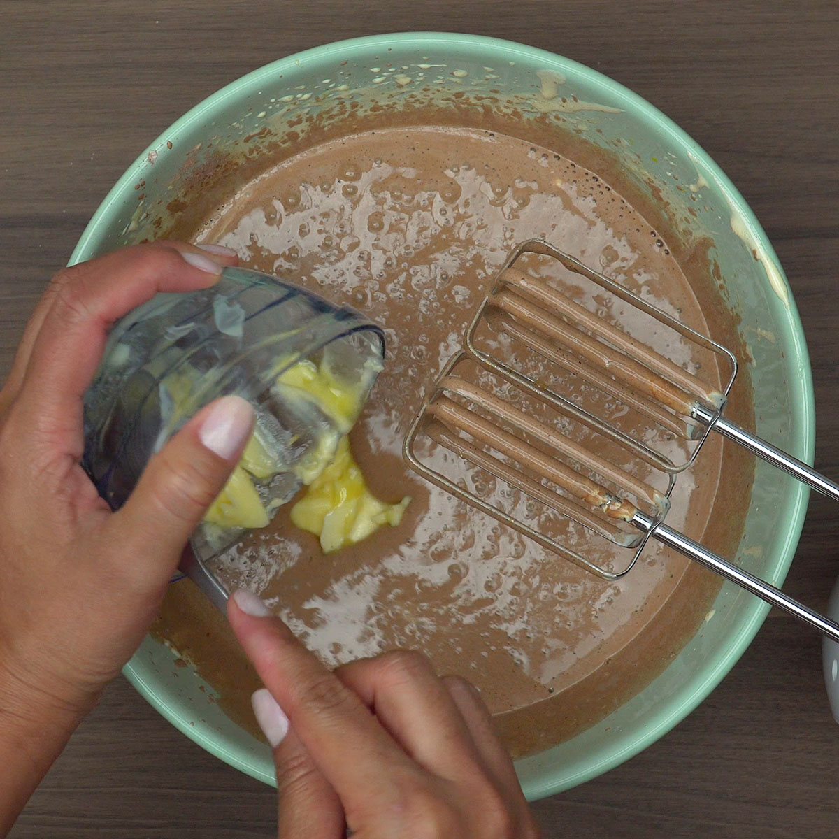 Manteiga sendo incorporada à massa de bolo de chocolate.