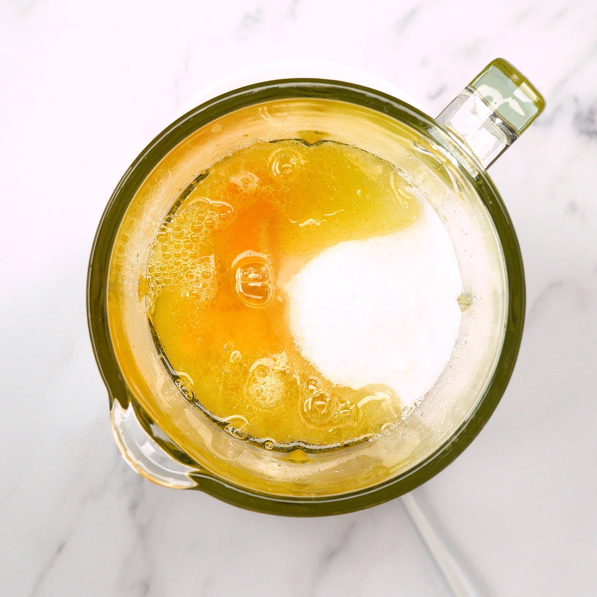 Ingredientes líquidos sendo batidos no liquidificador para preparar bolo de laranja.