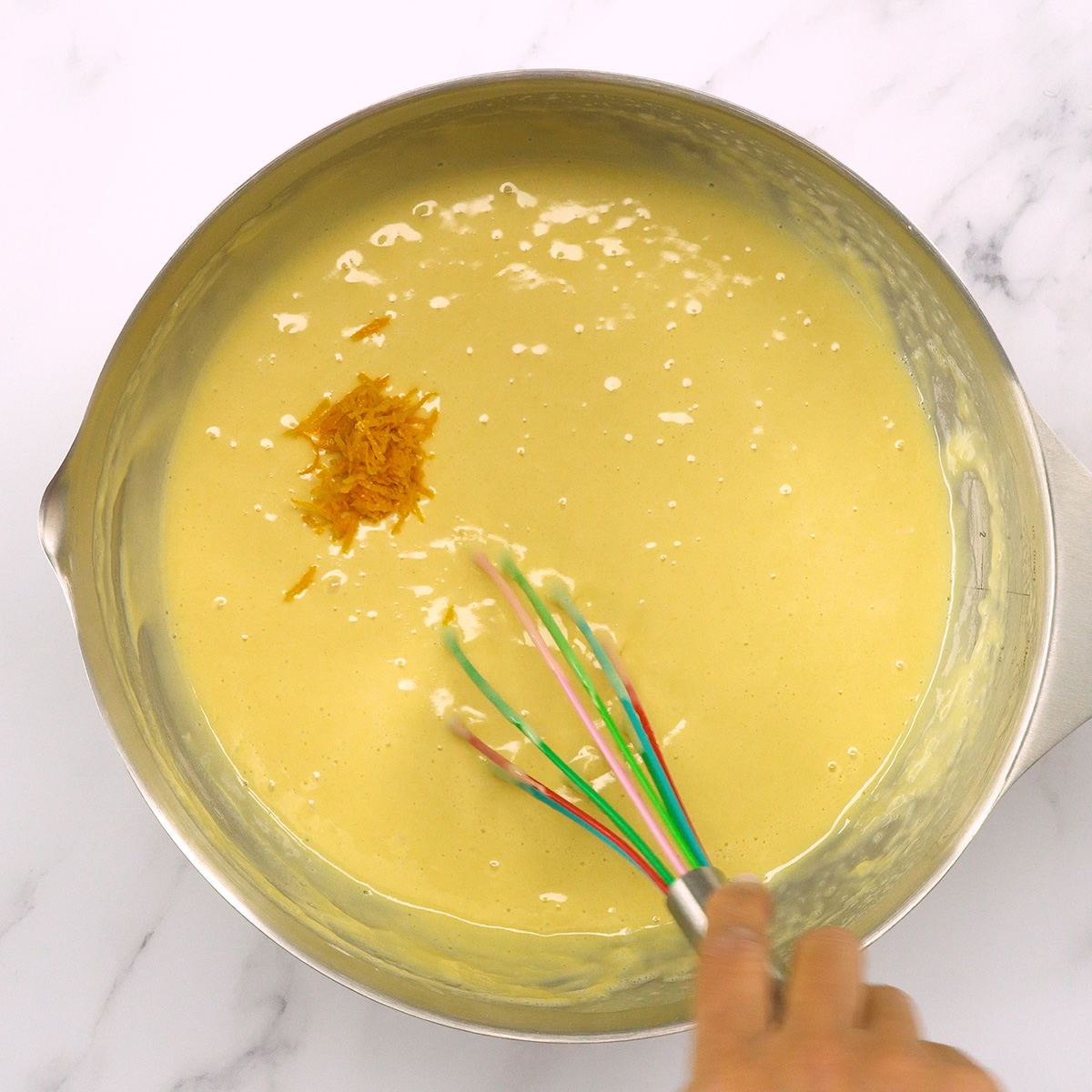 Raspas de laranja adicionadas à massa de bolo caseiro fofinho.