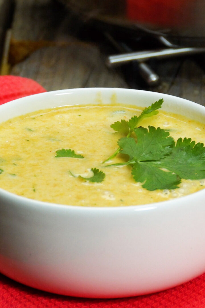 Caldo de mocotó pronto servido na tigela com salsa de decoração.