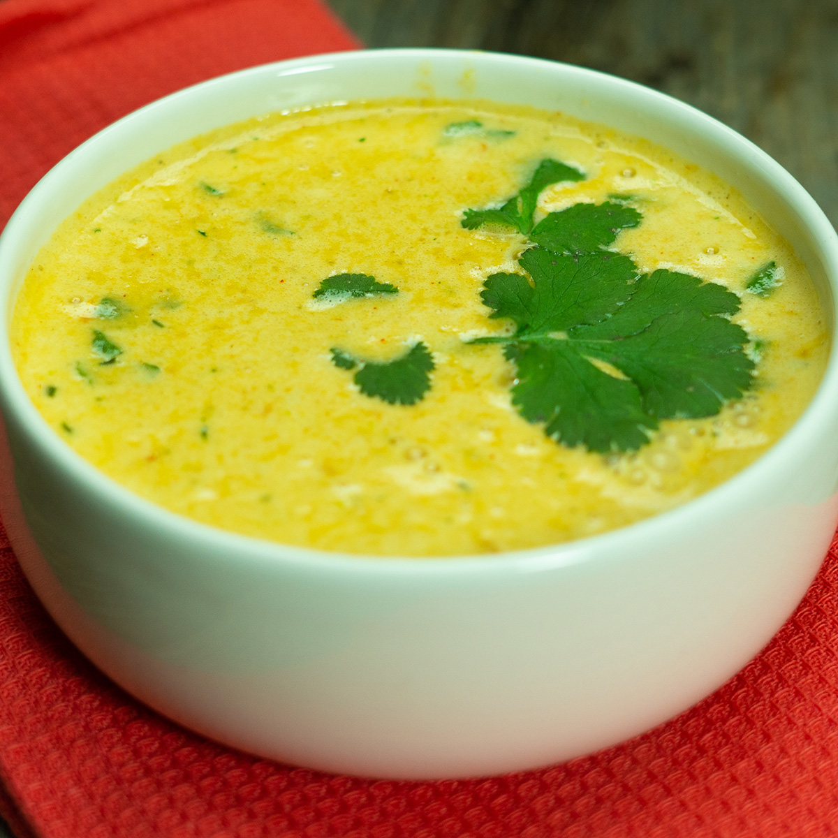 Caldo de mocotó pronto servido na tigela com salsa de decoração.