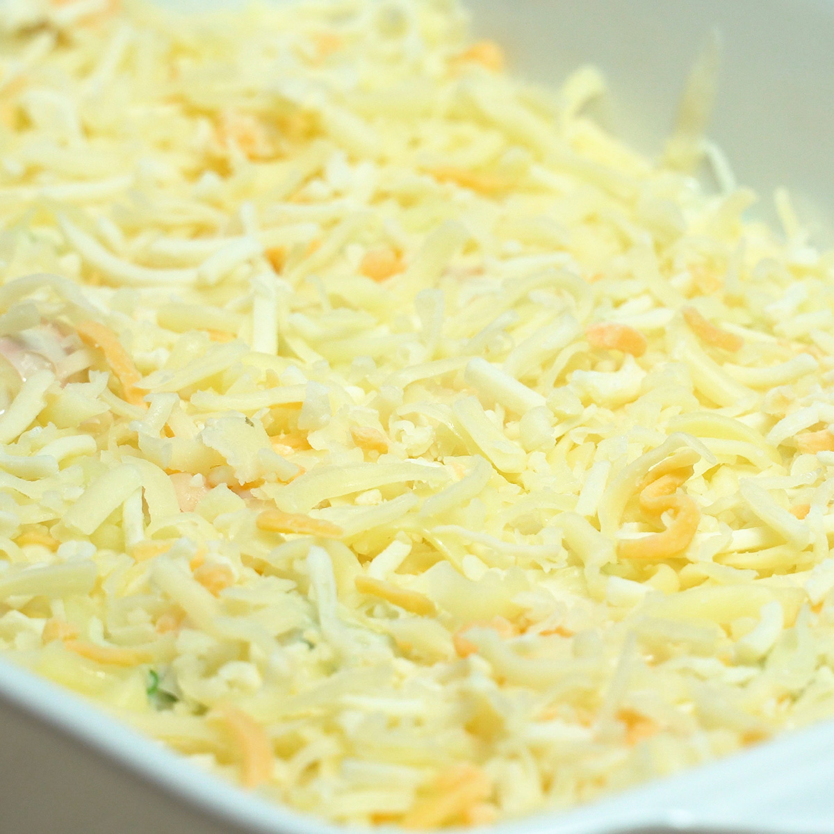 Travessa de camarão cremoso coberta com queijo mozzarella ralado.