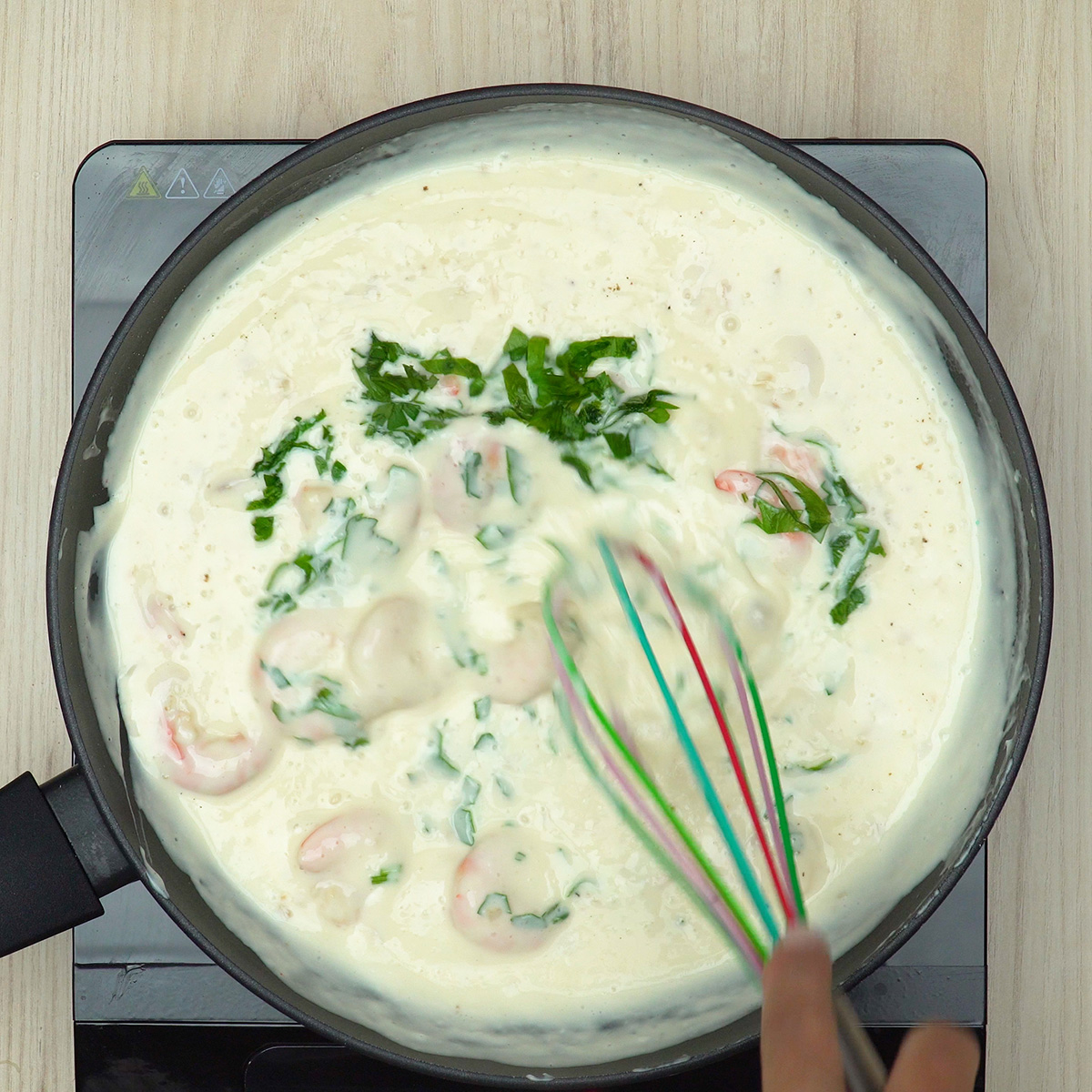 Camarões misturados ao molho cremoso com salsa fresca.