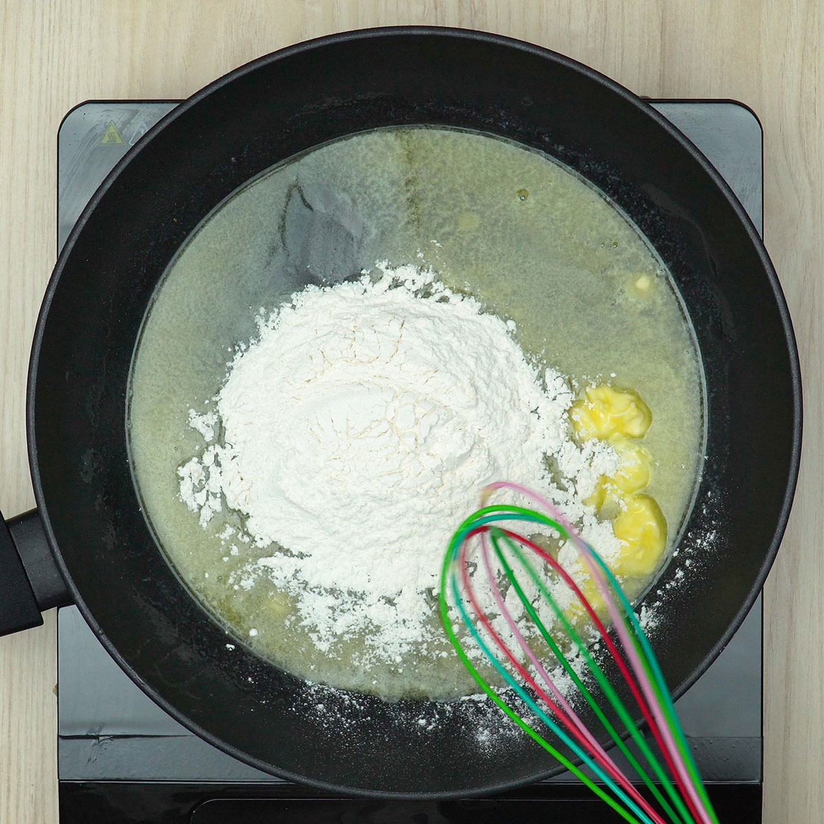 Mistura de manteiga e farinha preparando molho branco cremoso.