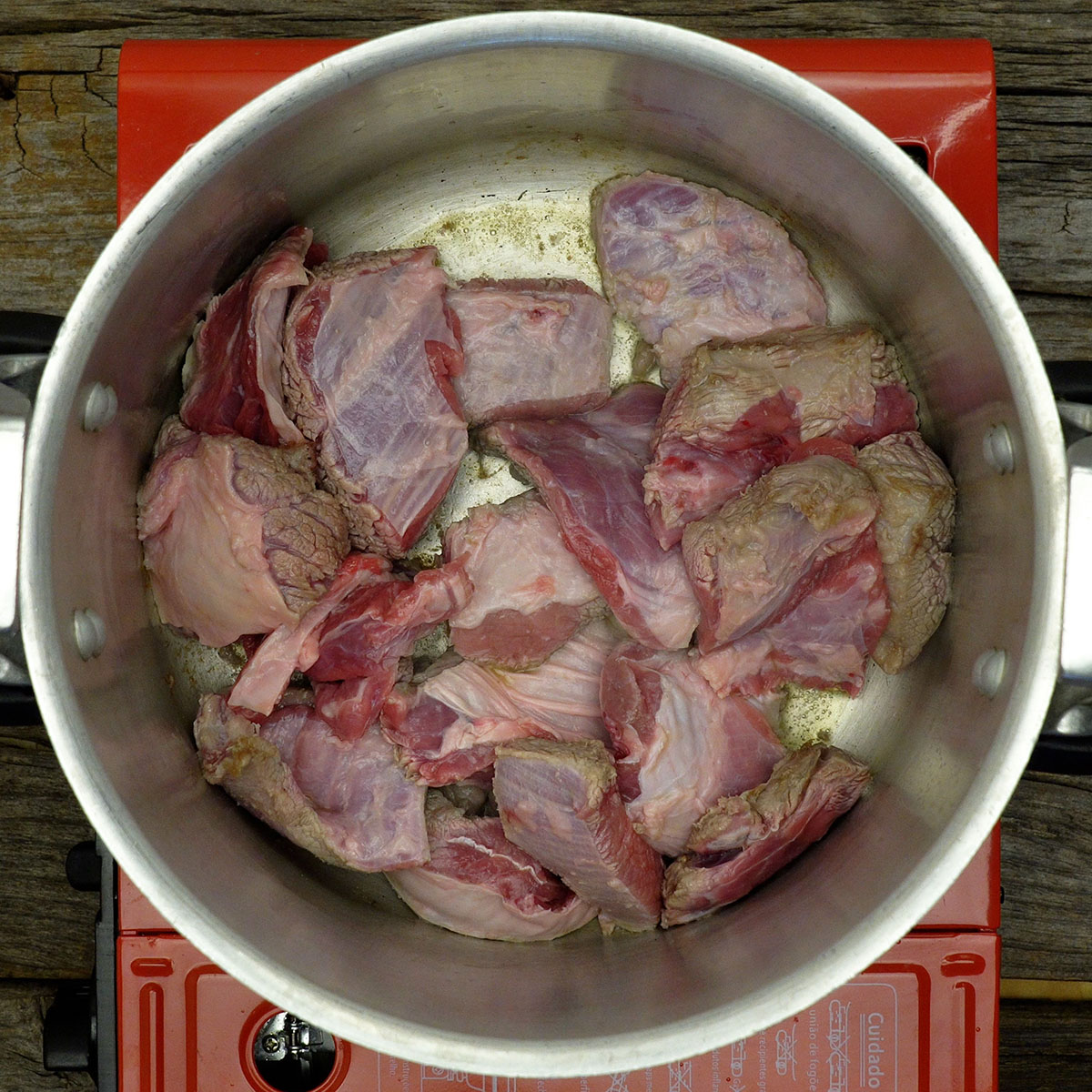 Carne bovina dourando na panela com azeite quente.