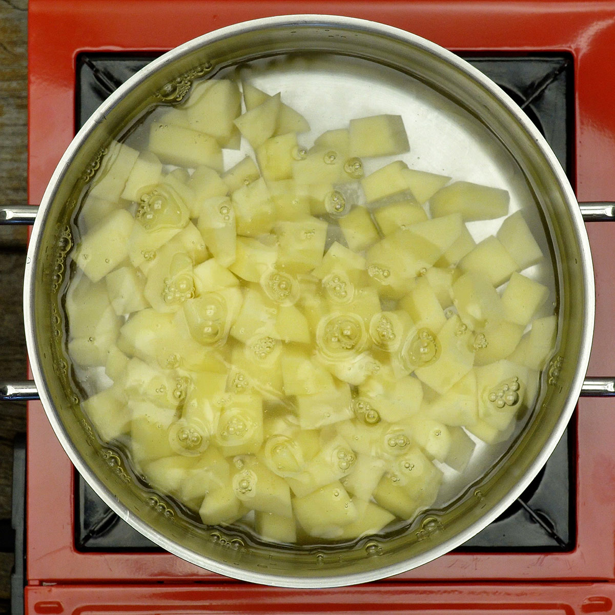 Batatas cozidas em cubos para preparar a salada.